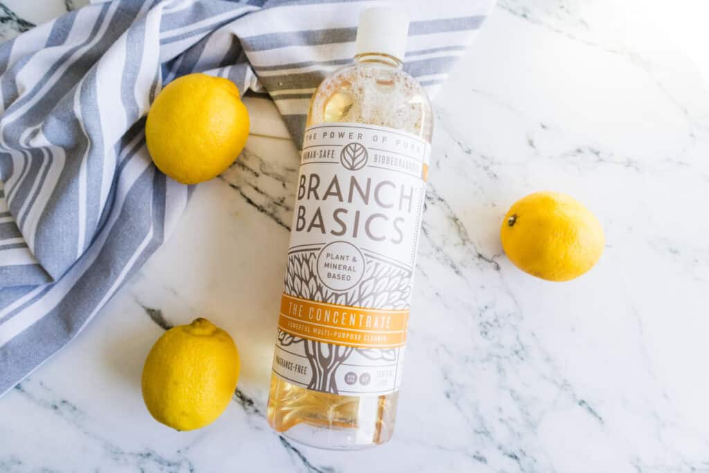 branch basics bottle on counter next to lemons and gray towel