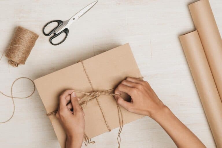 woman wrapping gift with yarn