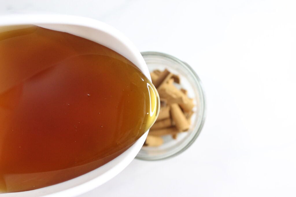 pouring honey over cinnamon sticks