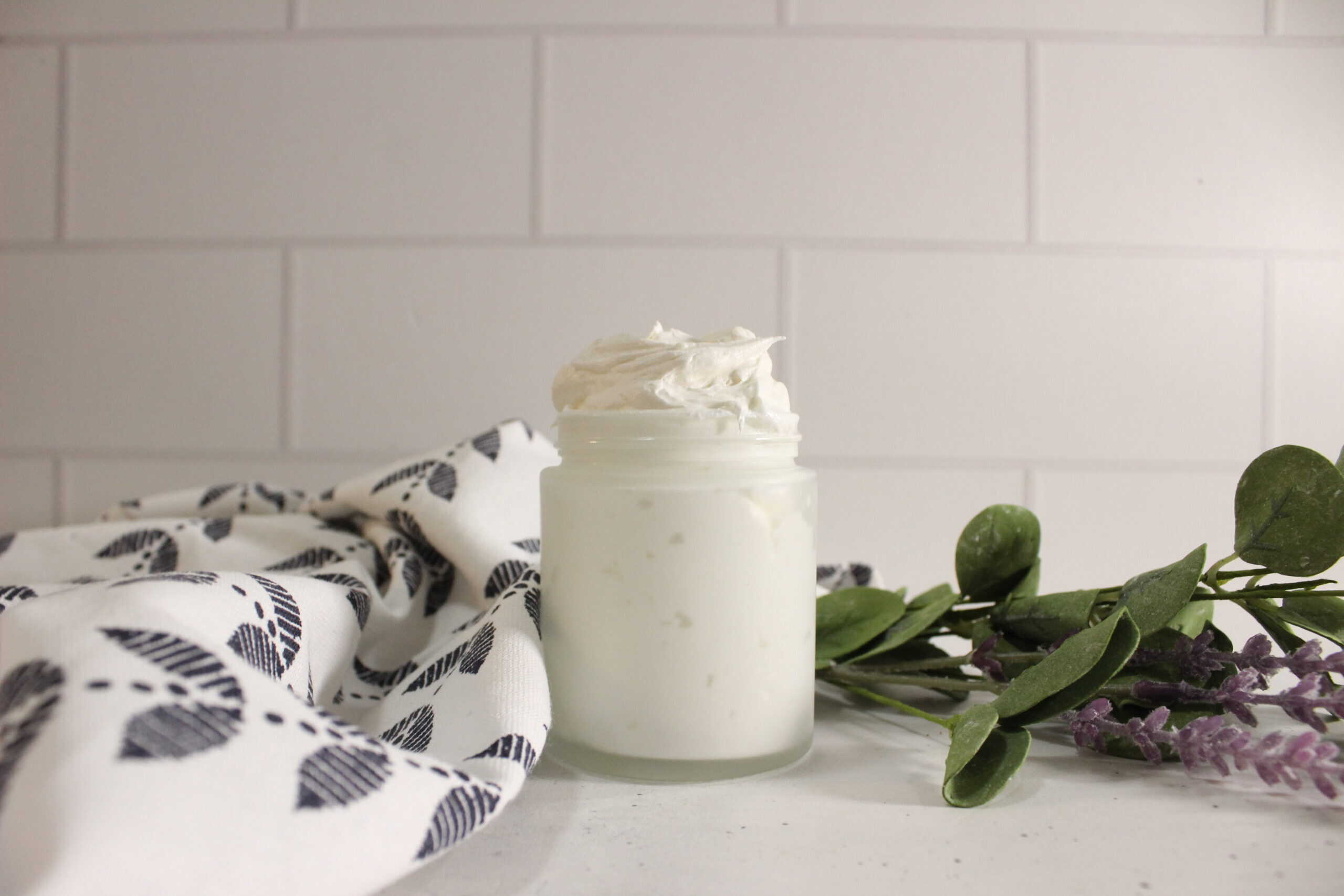 DIY CBD body butter in a jar on the counter