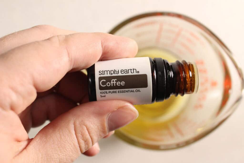 adding essential oil in the measuring cup