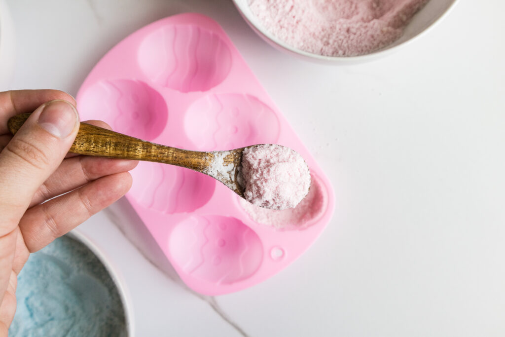 Adding the pink powder to Easter egg mold