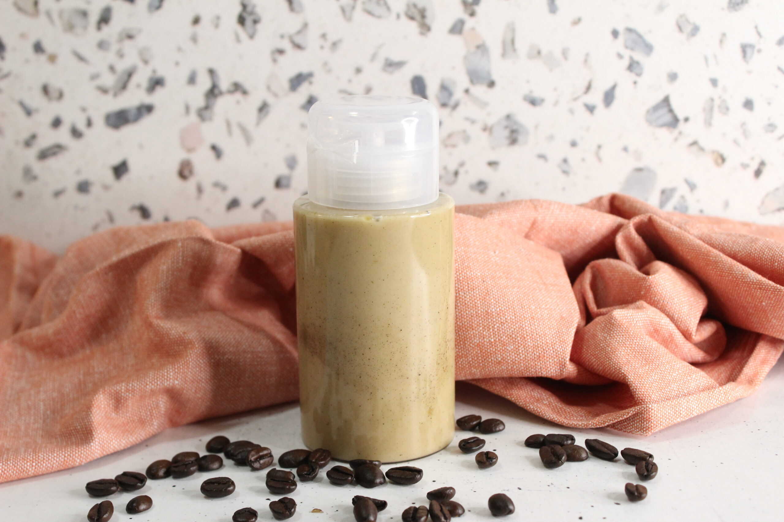 Coffee face wash in a bottle with coffee beans, ideal for skincare.