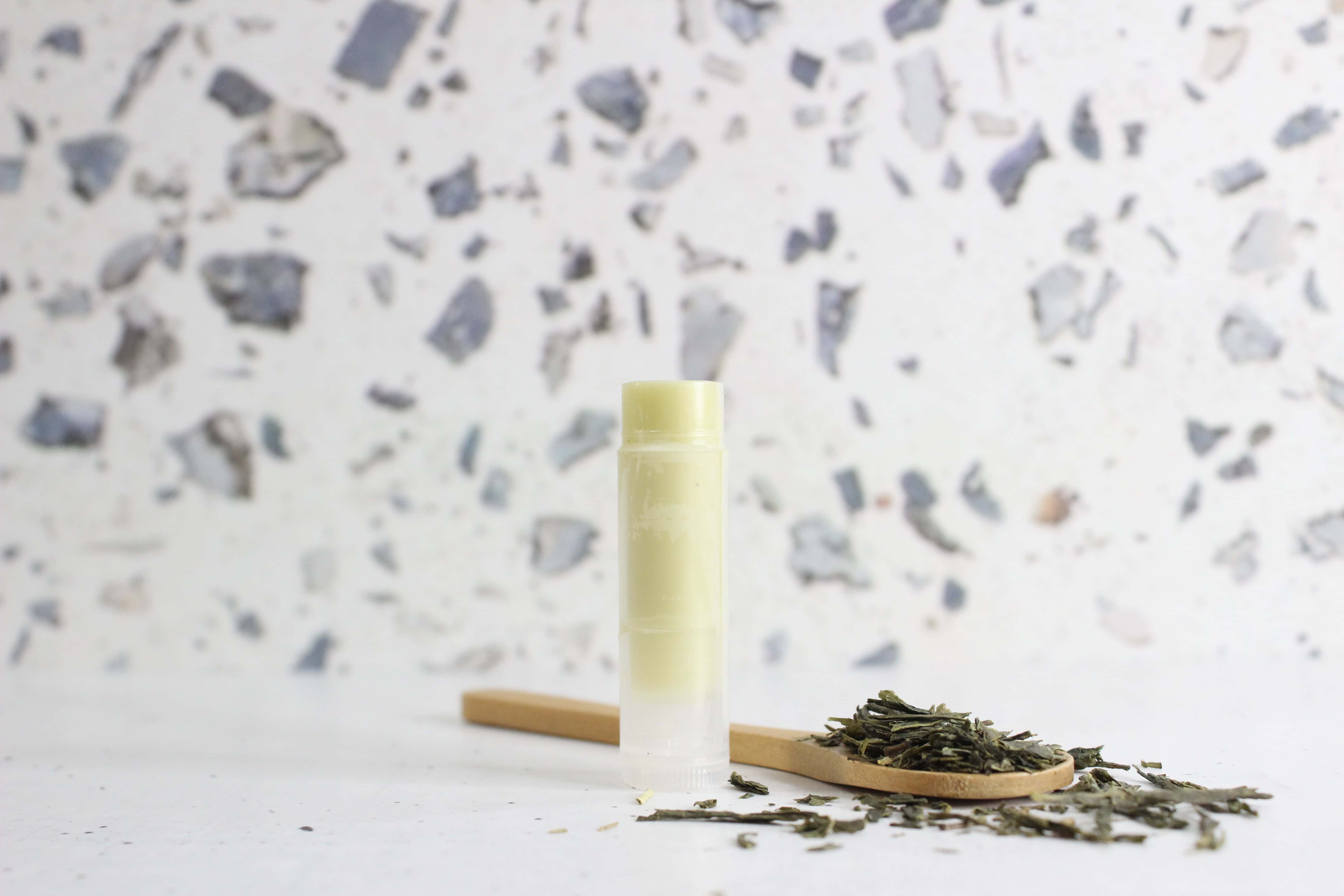 Green tea lip balm tube with loose tea leaves